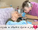 Opiekunka karmi starszą pacjentkę w hospicjum. Troska i szacunek w hospicjum dla osób starszych.