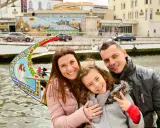 Familia feliz disfrutando de un paseo en góndola en Aveiro con niños. La niña hace el signo de la paz.