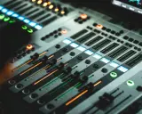 Console de mixage illuminée, prête pour le studio, le mixage et le mastering. Des faders et des boutons lumineux créent une ambiance professionnelle.