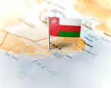 Flaga Omanu wbita w mapę, wskazująca gdzie leży Oman, nad Zatoką Omańską, w pobliżu Maskatu.