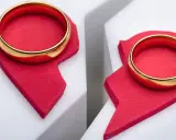Dwa złote obrączki na połówkach czerwonego serca, symbolizujące trudne rozstanie, nawet gdy się kocha.