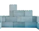 Una pared de bloques grises, apilados de forma irregular, simula un castillo de juguete.
