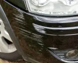 Dużo zarysowań na czarnym lakierze zderzaka. Widać, ile lakieru na zderzak zostało uszkodzone.