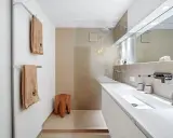 Bagno moderno con lavabo bianco, doccia a pioggia e dettagli in legno. Ottime idee per arredare bagno con stile minimalista.