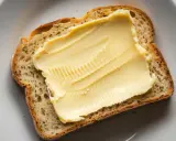 Eine Scheibe Brot mit einer dicken Schicht Butteralternative, die gut für die Cholesterinwerte ist.