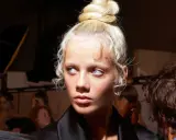 Ein Model mit einem eleganten Dutt und zarten Babyhaaren, die um das Gesicht fallen.