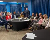 Grupa prawników siedzi przy okrągłych stołach podczas konferencji w Krakowie.