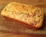 Un délicieux cake aux lardons, doré et moelleux, prêt à être dégusté sur une planche en bois.