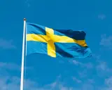 Svenska flaggan vajar i blå himmel. Dess korsdesign har en lång svenska flaggan historia, symboliserande nationens arv.