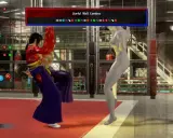 Wirtualny wojownik trenuje ciosy przy ścianie. Na ekranie widoczne są kombinacje ruchów z gry Virtua Fighter.