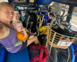 Familj i tuk-tuk med barn och cyklar, en del av en budgetresa i Thailand.