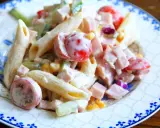 En krämig pastasallad med kassler, penne, körsbärstomater, gurka och majs. Perfekt för en snabb och god lunch.