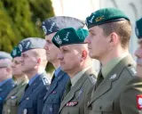 Żołnierze w zielonych i szarych beretach, prezentujący różne kolory mundurów wojska polskiego.