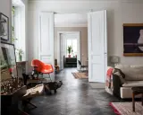 Erika Kangas hem med en katt som smyger förbi en orange stol och en soffa.