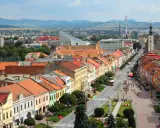 Widok na kolorowe kamienice wzdłuż ulicy, typowe dla największych miast Słowacji. W tle góry i zabudowania.