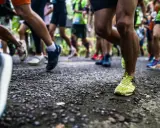 Läufer auf einer Strecke, die die halbmarathon distanz bewältigen. Fokus auf die Beine und Laufschuhe.