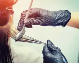 Mani guantate applicano tinta ai capelli. Scopri quanto dura una tinta dal parrucchiere per un colore impeccabile.