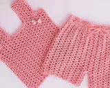 Conjunto de top y pantalón corto de crochet rosa para niña. El pantalón corto tiene un cordón para ajustar.
