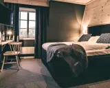 Mysigt rum på vandrarhem i Åre med stor säng, TV och fönster med utsikt.