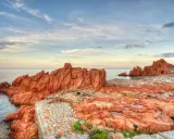 Scogliere rosse e sentiero in pietra a picco sul mare. Un luogo suggestivo da scoprire: Arbatax cosa vedere.