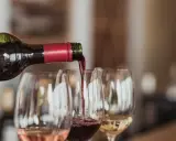 Rödvin hälls upp i glas under en vinprovning i Skåne. Rosé och vitt vin syns också.