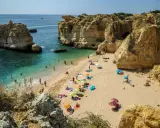 Słoneczna plaża w Algarve, z turkusową wodą i skalnymi klifami. Idealne miejsce, by zobaczyć piękno Portugalii.