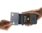 Płatności zbliżeniowe iPhone: karta Mastercard zbliżona do telefonu, wyświetlona kwota 67,75 zł.