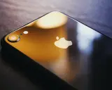 Ciemny iPhone z logo Apple. Dowiedz się, jak zmienić Apple ID, aby zabezpieczyć swoje dane.