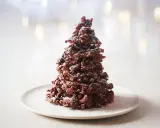 Un sapin chocolat mikado, saupoudré de sucre glace, sur une assiette blanche. Un délice festif !