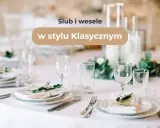 Eleganckie nakrycie stołu na wesele w stylu klasycznym. Biały obrus, szkło, zielone gałązki i menu tworzą wyrafinowaną atmosferę.