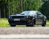 Schwarzer Dodge Challenger SRT Hellcat Redeye parkt am Waldrand.
