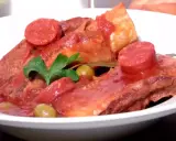 Plats de poitrine de veau mijotée, garnie de rondelles de chorizo, d'olives vertes et d'une feuille de laurier. Une recette savoureuse.