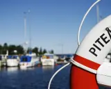 Livboj med texten PITEÅ K visar en hamn med båtar. Ett perfekt ställe att besöka Piteå på!