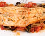 Leckerer Barsch zubereitet mit Tomaten, Zwiebeln und Oliven, garniert mit Kräutern. Ein Genuss für jeden Fischliebhaber.