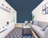 Un salon moderne avec un canapé gris, une table basse en verre et un tapis à motifs. Le plafond bleu foncé donne une impression de profondeur, une astuce pour comment agrandir une pièce.