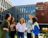 Grupa studentów śmieje się przed budynkiem Wyższej Szkoły Bankowej w Sosnowcu.