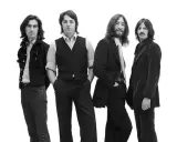 Les quatre membres des Beatles posent pour une photo en noir et blanc.