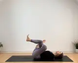 Frau in Yoga-Pose auf Matte, entspannt während ihrer Yoga-Periode.