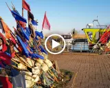 Stos kolorowych flag rybackich i bojki na nabrzeżu przy łodziach.