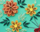 Kwiaty z papieru wykonane techniką quilling dla początkujących. Pomarańczowe, żółte i czerwone kwiaty oraz zielone i białe listki na turkusowym tle.