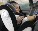 Bebé sonriente en silla de coche, grupo 0 hasta 18kg. Viaje seguro para los más pequeños.