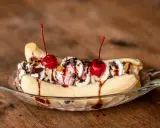 Un déliceux banana split avec glace, crème fouettée, pépites de chocolat et cerises. Une recette parfaite pour un dessert gourmand.