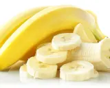 Kilka żółtych bananów, jeden obrany i pokrojony w plastry. Idealny banan na zatrucie pokarmowe.