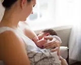 Matka karmi piersią dziecko, zastanawiając się, czy ibuprofen jest bezpieczny.
