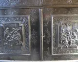 Détail d'un meuble Louis XIII sculpté de scènes bibliques et de motifs floraux.