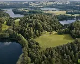 Krajobraz z jeziorami i lasami, typowy dla tego, z czego słynie Podlasie. Zielone pola i spokojne wody tworzą malowniczy widok.