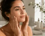 Mujer con piel radiante, aplicando crema. Su rostro refleja un brillo natural, el verdadero que es glow.