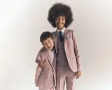 Two boys in matching dusty rose suits, showing what ring bearers wear: tailored jackets, vests, shirts, and ties.