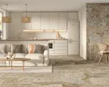 Elegante salón-cocina con sofá beige, mesa de centro de madera y suelos de cemento con un diseño rústico y texturizado.