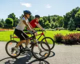 Dwie osoby na rowerach cieszą się słonecznym dniem w parku. Ile czasu zajmie im przejechanie 20 km rowerem?